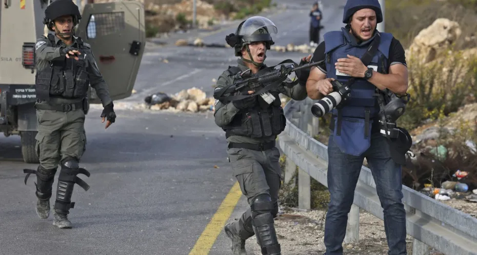 An Israeli soldier shoves a journalist at the northern entrance to the city of Ramallah