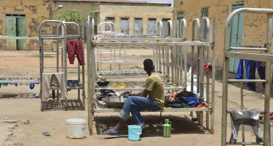 A displaced man who fled the ongoing violence by two rival Sudanese generals, rests on a bed in a shelter,