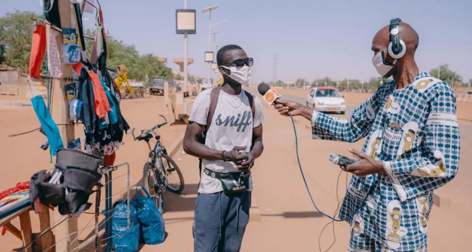 Two women interviewing a man in Nigeria.