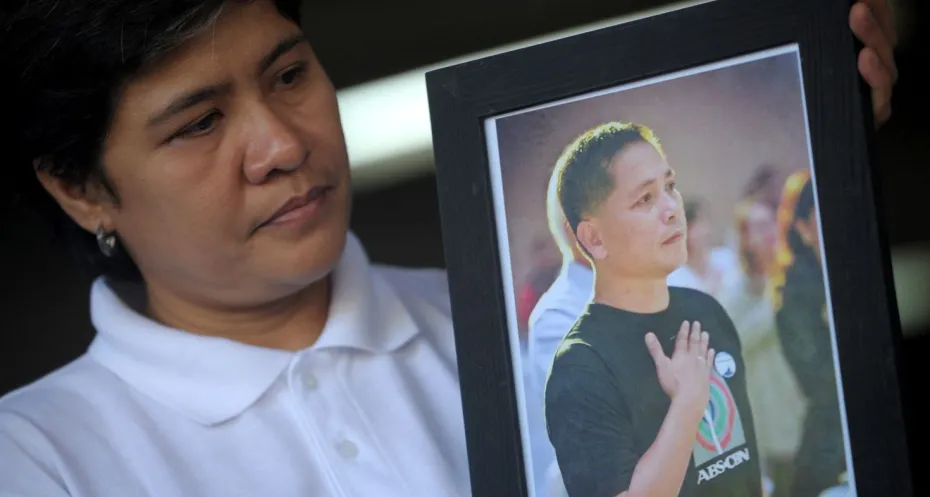 Gerry Ortega's wife holding a photo of Gerry Ortega