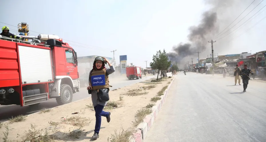 A journalist runs away from the site of a bomb attack in Kabul, capital of Afghanistan