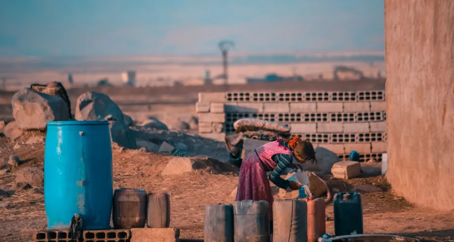 A child fills water containers from a public tank in the city of Derik/Al-Malikiyah in northeastern Syria. Image from the Nextstep/Nextory project on climate justice.