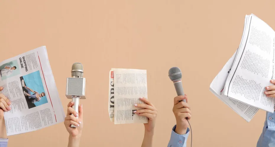 Journalisten houden microfoons en kranten omhoog